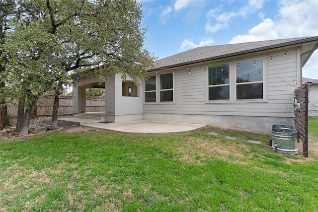 back of house featuring a lawn and a patio area