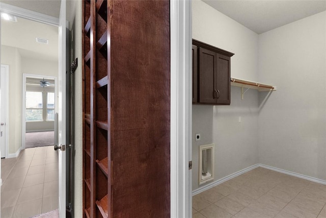 clothes washing area featuring light tile patterned floors, cabinets, and hookup for an electric dryer