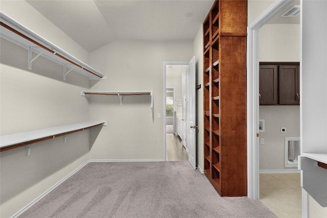 walk in closet featuring light tile patterned flooring and vaulted ceiling