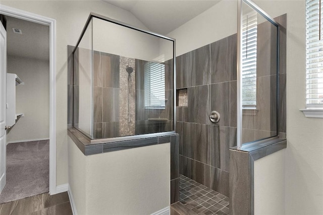 bathroom with lofted ceiling and a tile shower