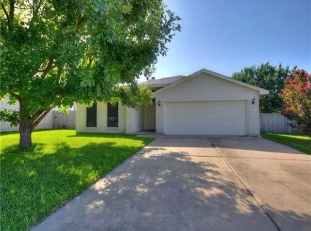 view of front of property with a garage, concrete driveway, a front yard, and fence