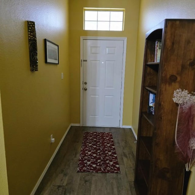 doorway to outside with wood finished floors and baseboards