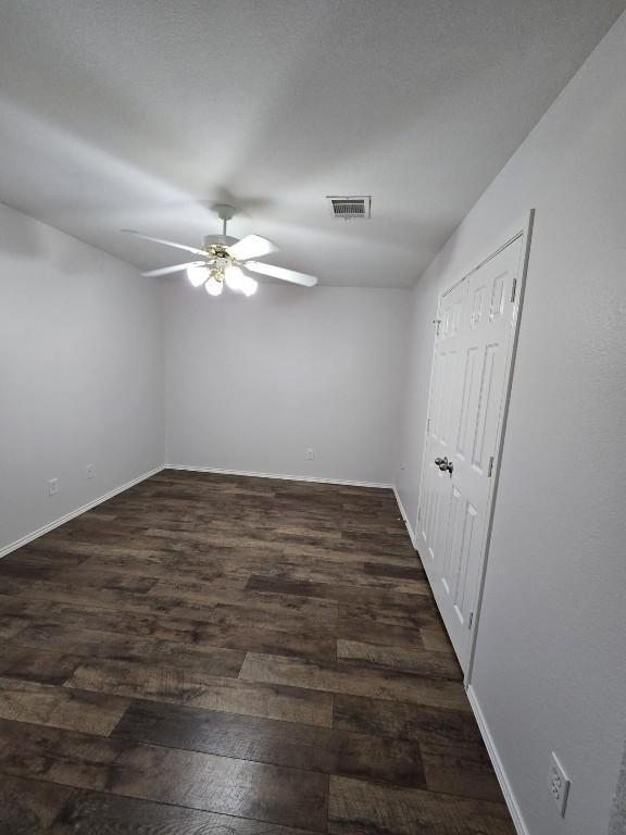 211 Valley Run Trl, Elgin, TX 78621 - empty room featuring visible vents, ceiling fan, dark wood finished floors, and baseboards