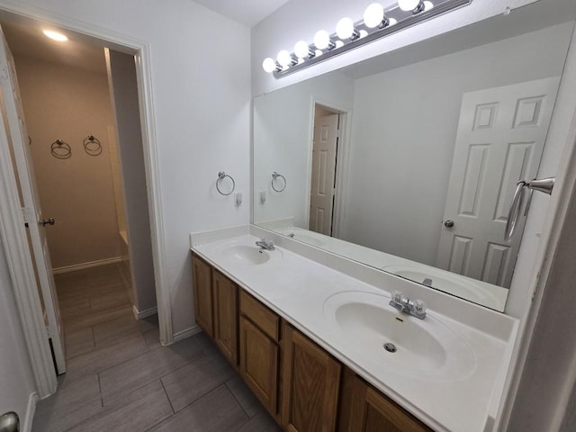 211 Valley Run Trl, Elgin, TX 78621 - bathroom featuring baseboards, double vanity, and a sink