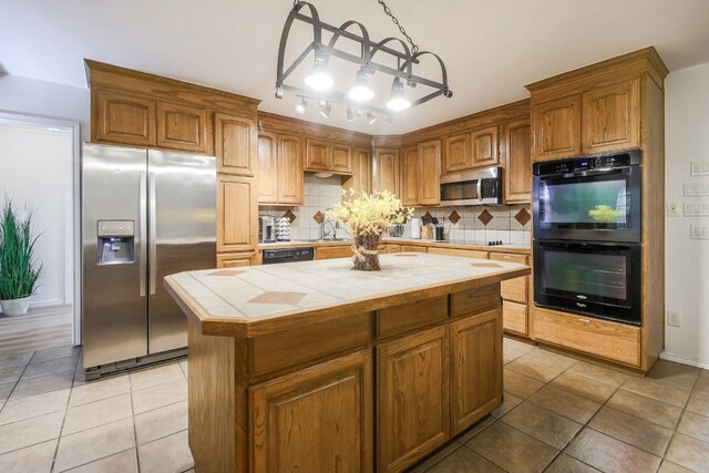 1000 Ledbetter St, Round Rock, TX 78681 - kitchen featuring black appliances, tile counters, light tile patterned floors, and a center island