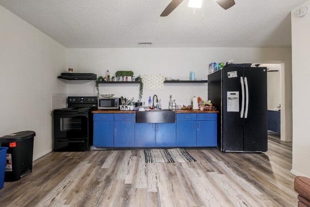 1000 Ledbetter St, Round Rock, TX 78681 - kitchen featuring black appliances, blue cabinets, open shelves, wood counters, and a textured ceiling