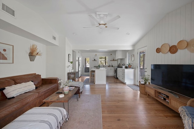 living room with ceiling fan and light wood-type flooring