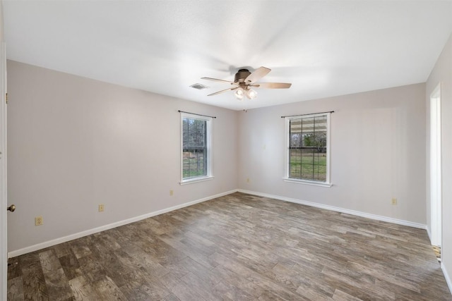 1252 County Road 106, Paige, TX 78659 - empty room featuring plenty of natural light, a ceiling fan, wood finished floors, and baseboards