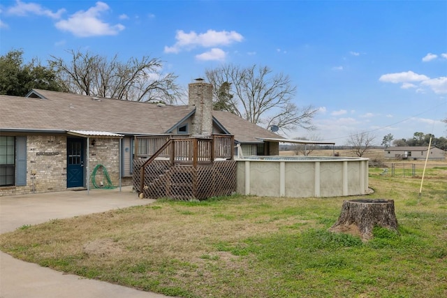 1252 County Road 106, Paige, TX 78659 - back of house with a wooden deck, a yard, a chimney, and an outdoor pool