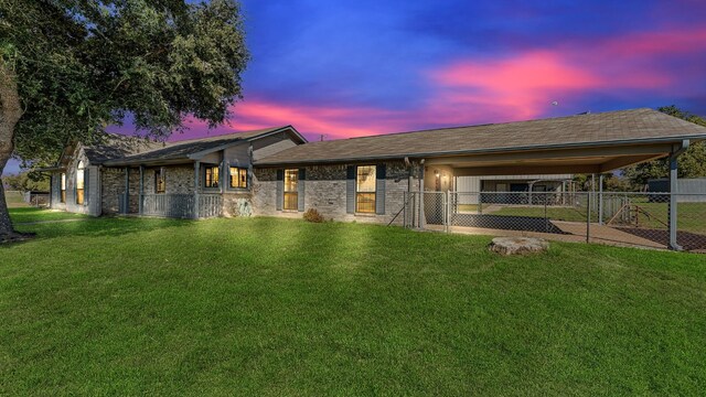 1252 County Road 106, Paige, TX 78659 - back of house at dusk featuring a gate, a lawn, a carport, and fence