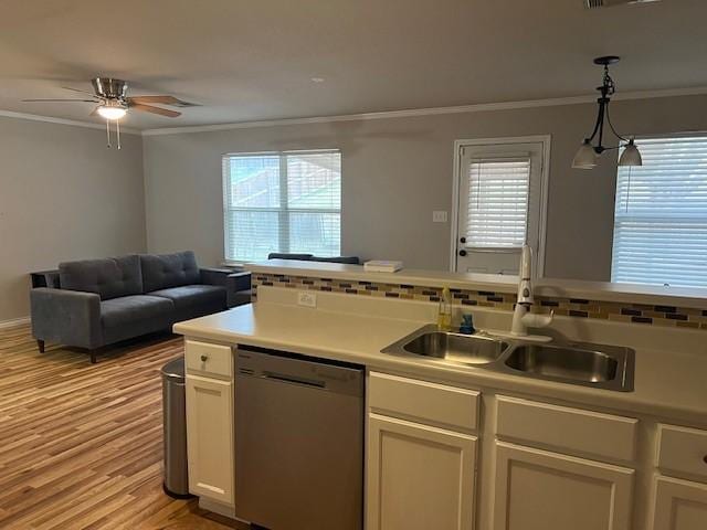 kitchen with sink, dishwasher, hanging light fixtures, plenty of natural light, and ornamental molding