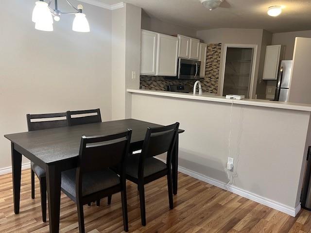 dining space with hardwood / wood-style flooring, sink, and an inviting chandelier