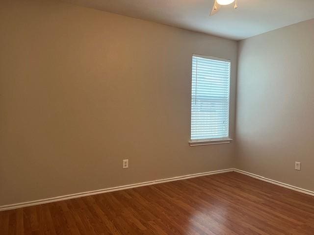 spare room featuring dark wood-type flooring and ceiling fan