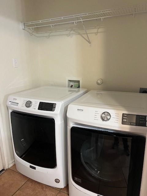 laundry room with separate washer and dryer and light tile patterned floors