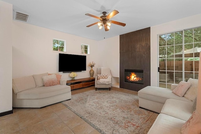 living room featuring a fireplace and ceiling fan