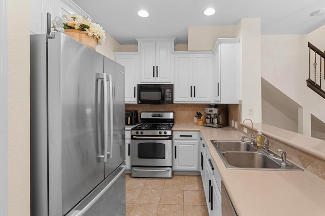 kitchen with light tile patterned flooring, sink, white cabinetry, stainless steel appliances, and decorative backsplash