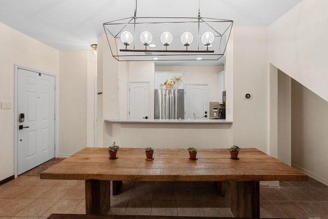 dining space featuring dark tile patterned flooring and a notable chandelier