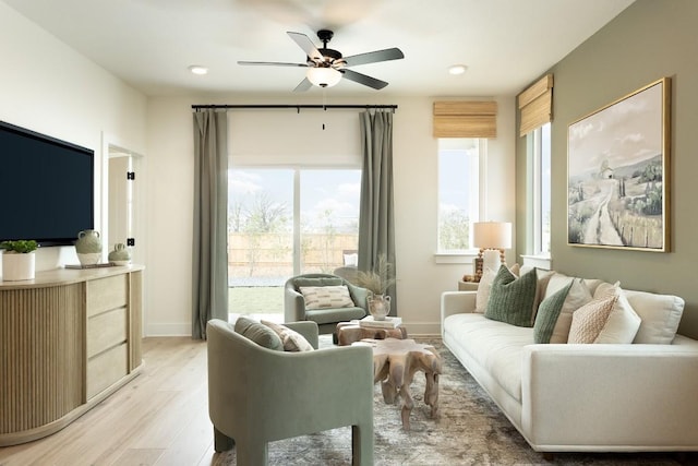 living room with ceiling fan and light hardwood / wood-style flooring