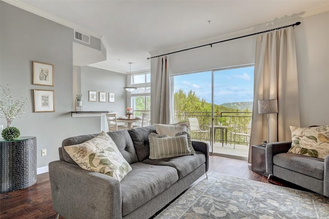 living area featuring ornamental molding, visible vents, baseboards, and wood finished floors