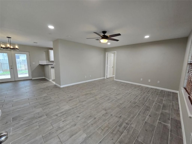 177 E Davilla St, Bartlett, TX 76511 - unfurnished living room with wood finished floors, ceiling fan with notable chandelier, french doors, baseboards, and recessed lighting