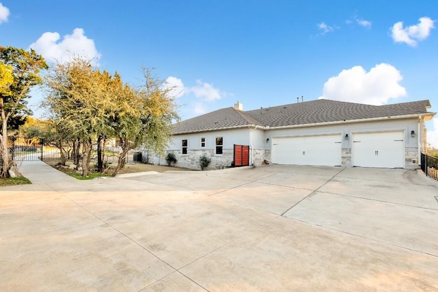 197 Bristlecone Dr, Driftwood, TX 78619 - view of front of house featuring a garage, stone siding, concrete driveway, and fence