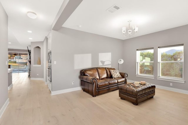 living room with a notable chandelier and light hardwood / wood-style floors