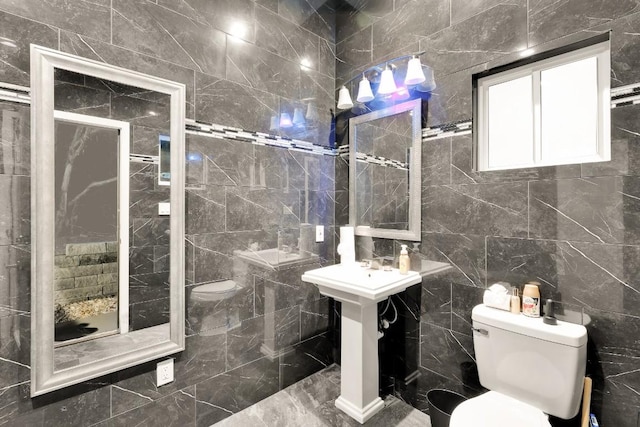 bathroom with tiled shower, toilet, and tile walls