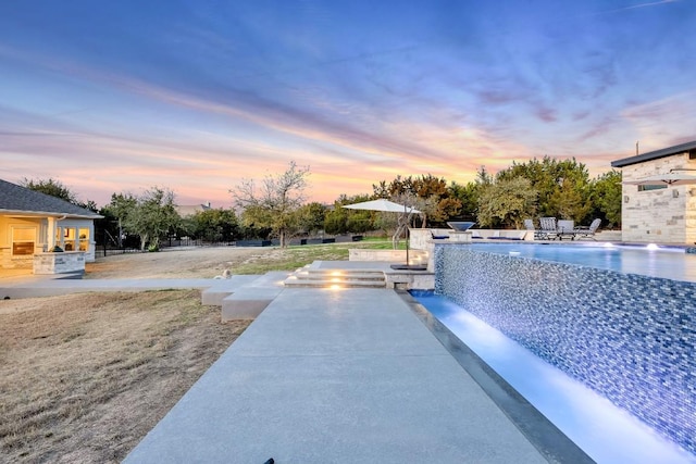 exterior space with a patio area, pool water feature, and exterior kitchen