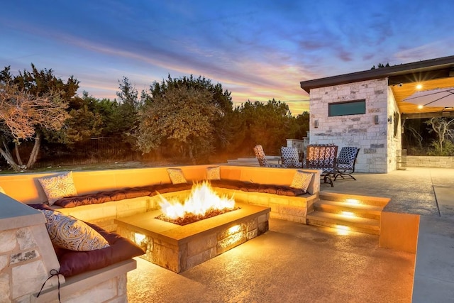 patio terrace at dusk featuring an outdoor fire pit