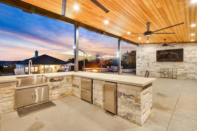 view of patio with ceiling fan, exterior kitchen, and sink