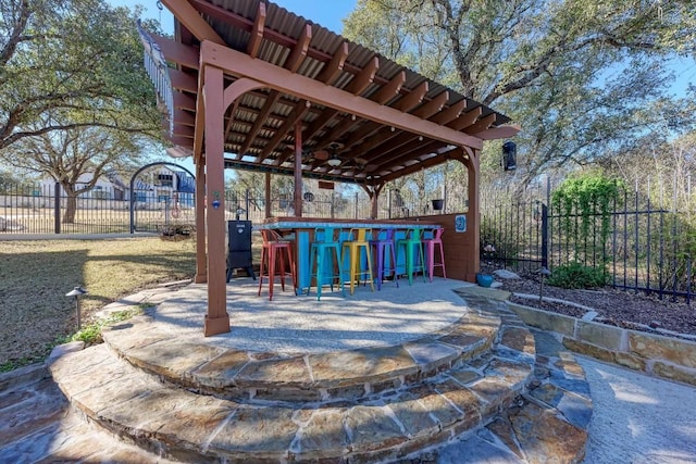 view of patio / terrace featuring ceiling fan and an outdoor bar