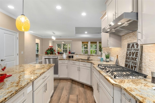 kitchen featuring stainless steel appliances, white cabinetry, sink, and decorative light fixtures