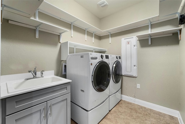 laundry area featuring cabinets, washer and clothes dryer, and sink