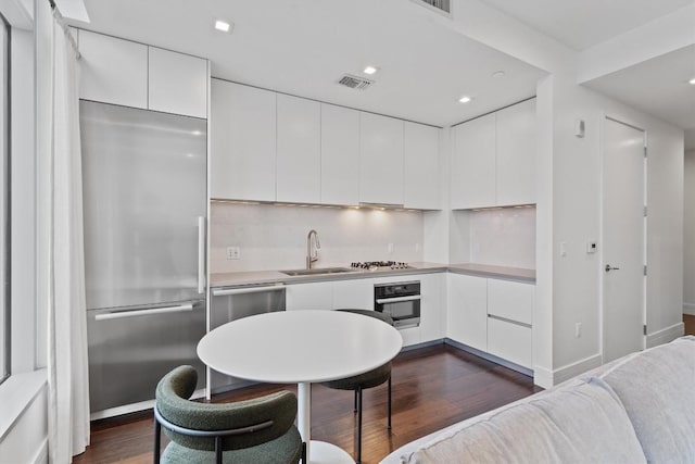 kitchen with appliances with stainless steel finishes, sink, and white cabinets