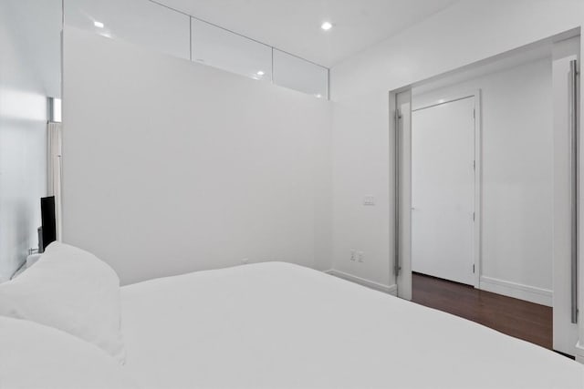 bedroom with dark wood-type flooring