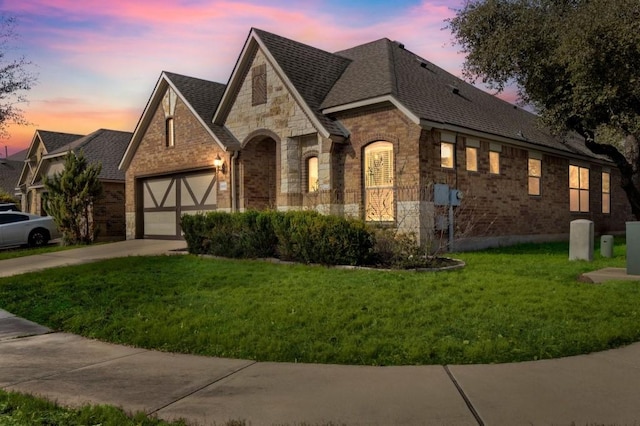 view of front of property with a garage and a lawn