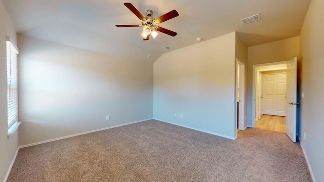 unfurnished room with plenty of natural light, light carpet, lofted ceiling, and ceiling fan