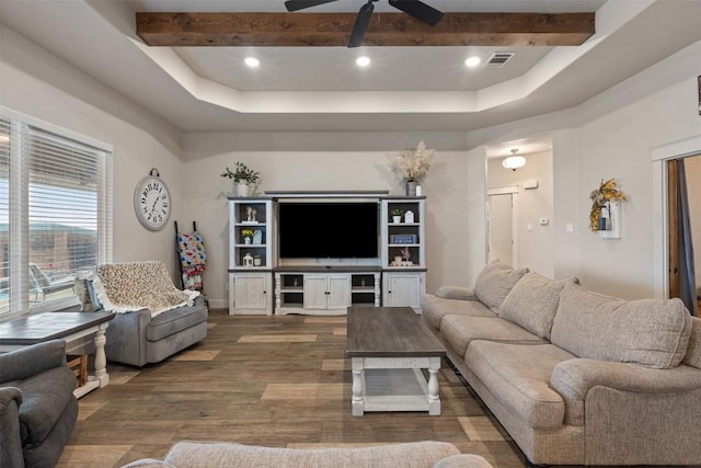 living room featuring ceiling fan, dark wood-type flooring, beam ceiling, and a tray ceiling