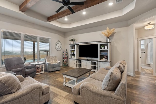 living room featuring ceiling fan, wood-type flooring, and beam ceiling