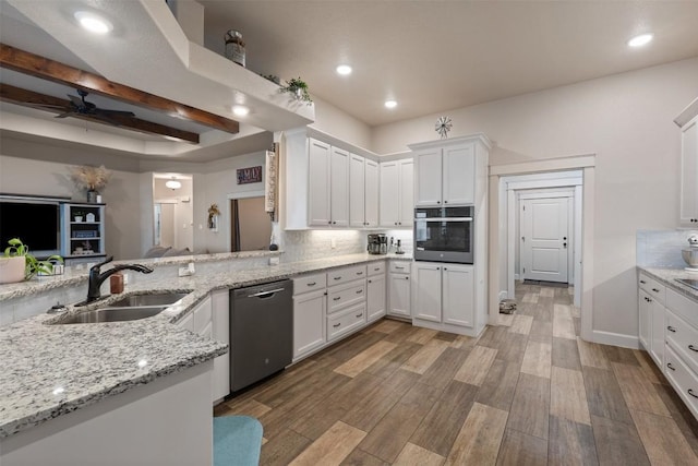 kitchen featuring white cabinetry, appliances with stainless steel finishes, sink, and light stone counters