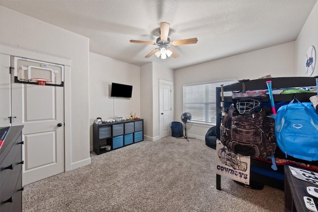 interior space with ceiling fan, carpet, and a textured ceiling