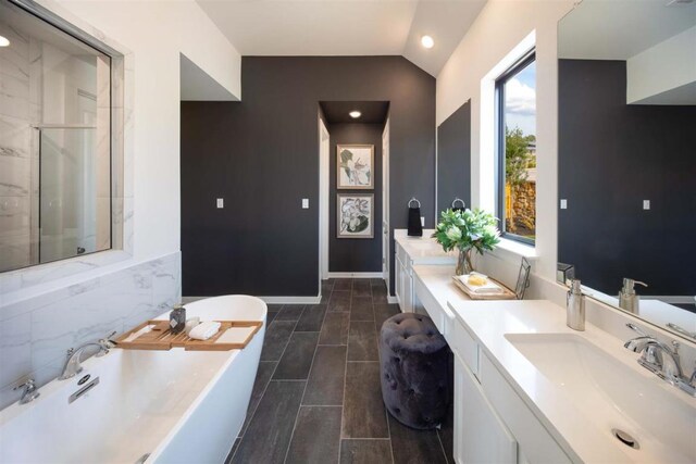 2516 Carretera Dr, Leander, TX 78641 - full bathroom with a freestanding tub, vaulted ceiling, vanity, tile patterned floors, and an enclosed shower
