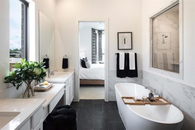 2516 Carretera Dr, Leander, TX 78641 - ensuite bathroom with double vanity, a sink, tile walls, a freestanding tub, and ensuite bath