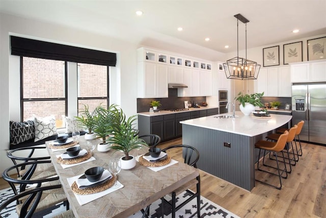 2516 Carretera Dr, Leander, TX 78641 - kitchen with a sink, stainless steel fridge with ice dispenser, a center island with sink, light countertops, and tasteful backsplash