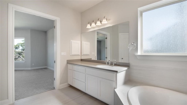 bathroom featuring vanity, a tub to relax in, and plenty of natural light