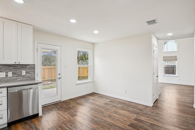 kitchen featuring white cabinetry, stainless steel dishwasher, backsplash, and dark hardwood / wood-style flooring