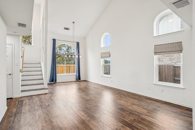 unfurnished living room featuring dark hardwood / wood-style floors and high vaulted ceiling