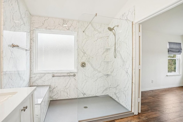 bathroom featuring vanity, wood-type flooring, and a tile shower