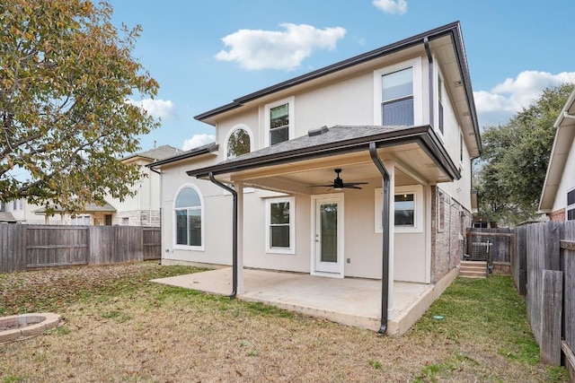 back of house featuring ceiling fan, a patio area, and a lawn