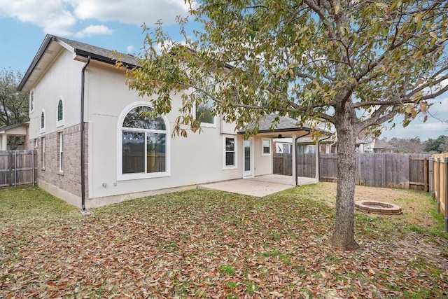 back of house featuring an outdoor fire pit and a patio